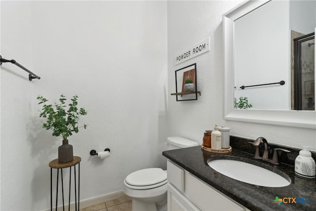 bathroom featuring toilet, vanity, tile patterned floors, and baseboards