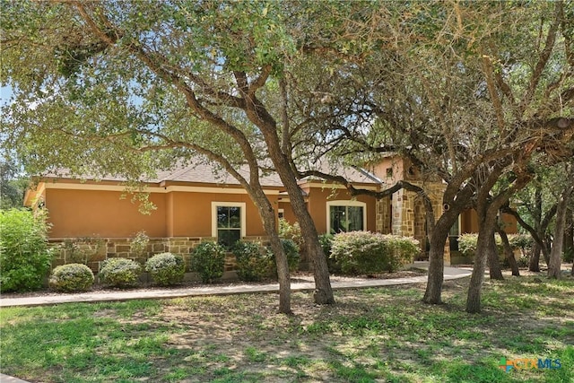 view of front of property featuring stucco siding and stone siding