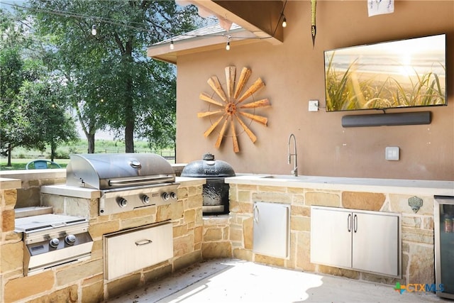 view of patio with a grill, wine cooler, exterior kitchen, and a sink