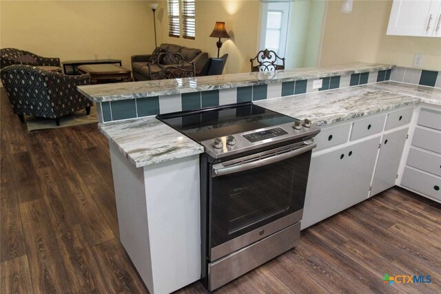 kitchen featuring white cabinets, dark hardwood / wood-style floors, kitchen peninsula, and electric range