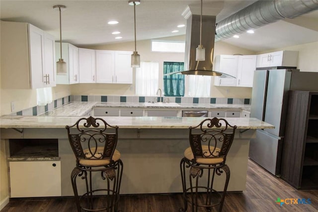 kitchen featuring white cabinets, a kitchen bar, dark wood-type flooring, and lofted ceiling