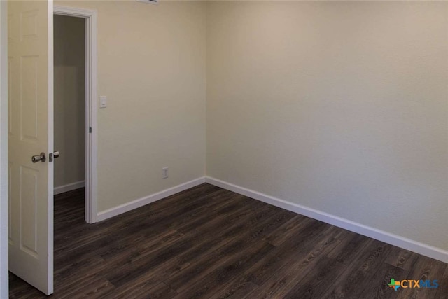 unfurnished room with dark wood-type flooring