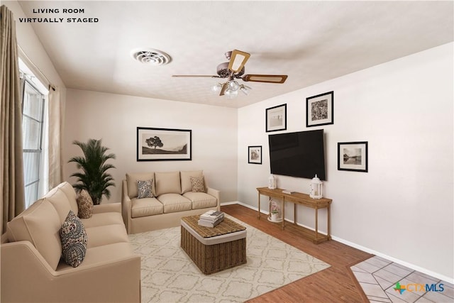 living room with wood-type flooring and ceiling fan