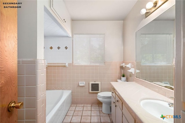 bathroom with tile patterned floors, vanity, tile walls, and a tub