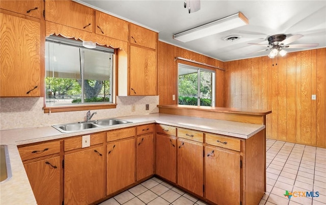 kitchen with sink, ceiling fan, tasteful backsplash, light tile patterned flooring, and kitchen peninsula