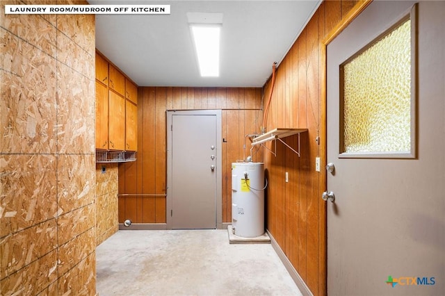 laundry area with water heater and wood walls