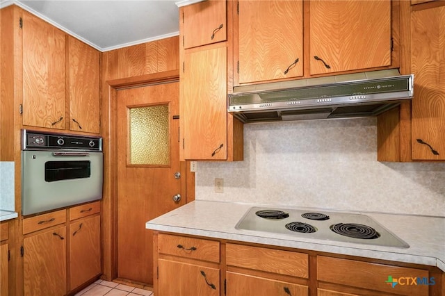 kitchen featuring light tile patterned floors, decorative backsplash, cooktop, and white oven