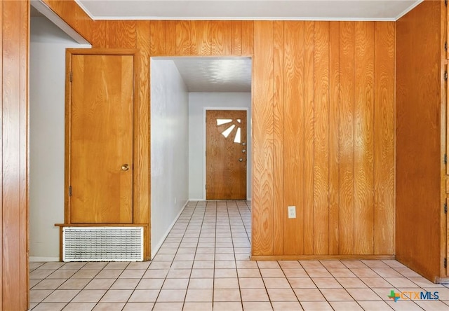 corridor with light tile patterned floors and crown molding