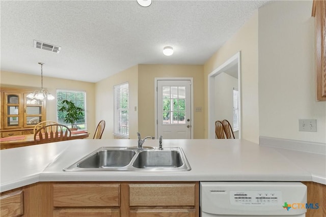 1233 Oakcrest Dr, Pleasanton, TX 78064 - kitchen with white dishwasher, light countertops, a textured ceiling, and decorative light fixtures