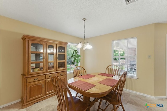 1233 Oakcrest Dr, Pleasanton, TX 78064 - dining room with a chandelier, a textured ceiling, and light tile patterned floors