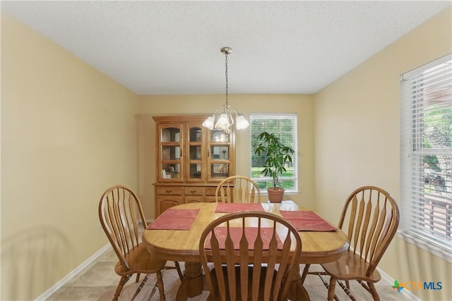 1233 Oakcrest Dr, Pleasanton, TX 78064 - dining area featuring healthy amount of natural light, a chandelier, and a textured ceiling