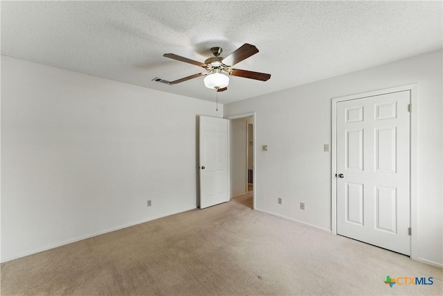 1233 Oakcrest Dr, Pleasanton, TX 78064 - unfurnished bedroom featuring light colored carpet, a textured ceiling, and a ceiling fan