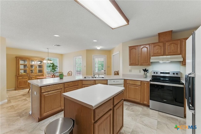 1233 Oakcrest Dr, Pleasanton, TX 78064 - kitchen with stainless steel electric range, under cabinet range hood, a peninsula, light countertops, and recessed lighting