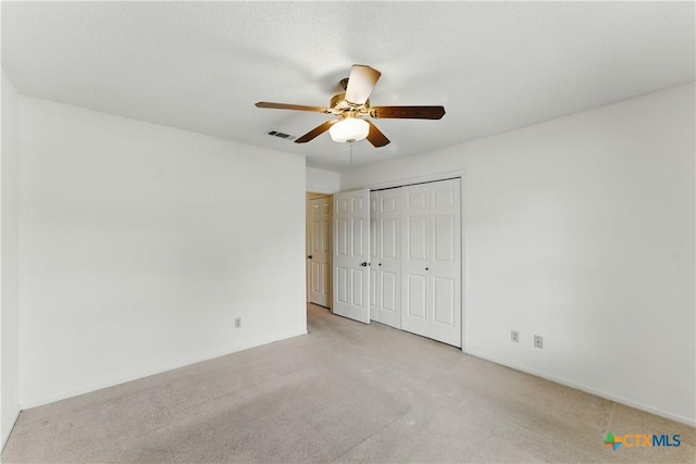 1233 Oakcrest Dr, Pleasanton, TX 78064 - unfurnished bedroom featuring light colored carpet, a closet, and a ceiling fan