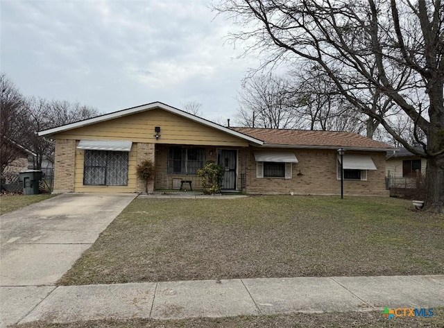 ranch-style house featuring a front lawn, brick siding, and driveway