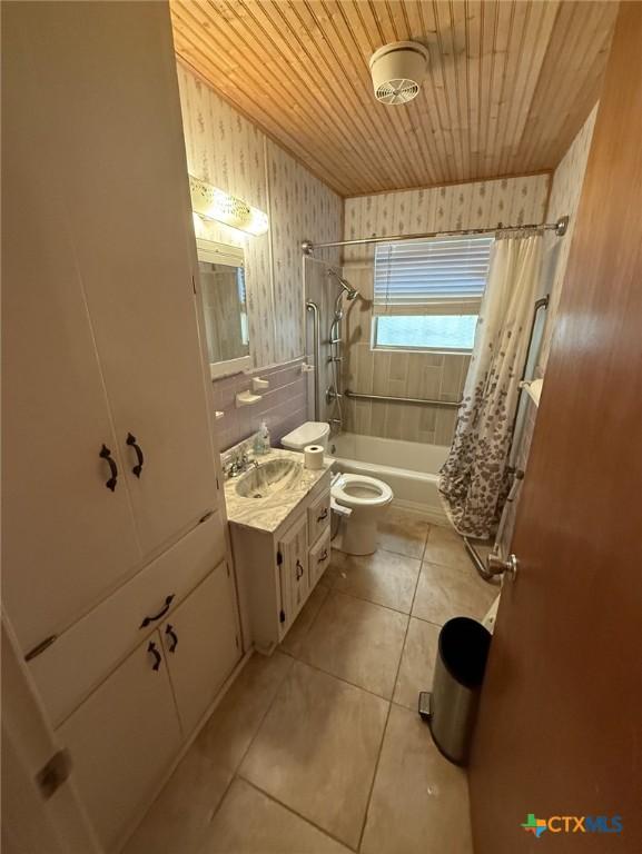 bathroom with wood ceiling, toilet, shower / bath combo with shower curtain, tile patterned floors, and vanity