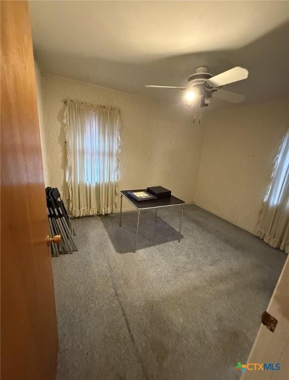 interior space with a ceiling fan and carpet floors