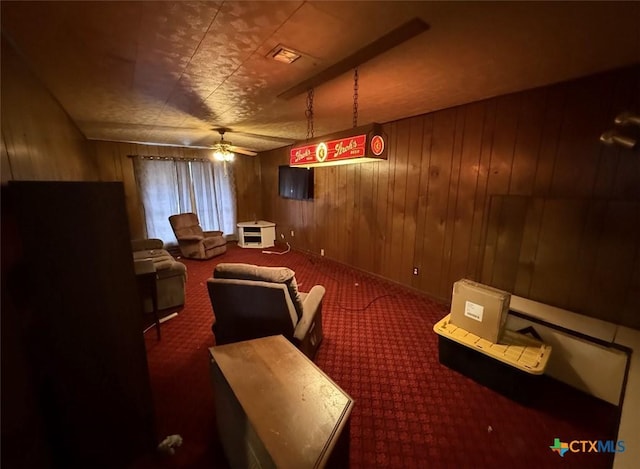 cinema featuring carpet flooring, wood walls, and ceiling fan