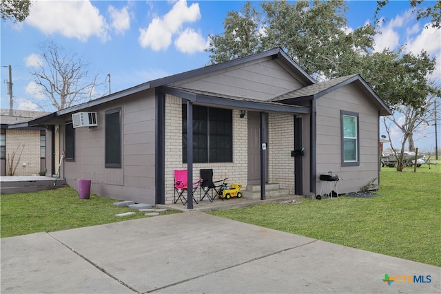 view of front facade with a front yard and an AC wall unit