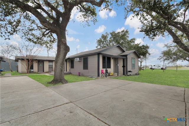 ranch-style home featuring a front yard and a wall mounted AC