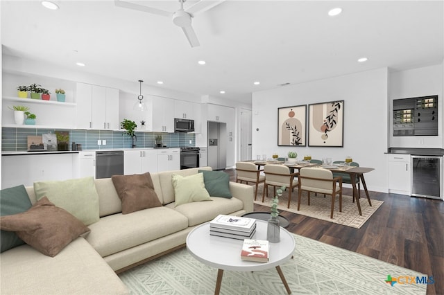 living room with sink, dark hardwood / wood-style floors, beverage cooler, and ceiling fan