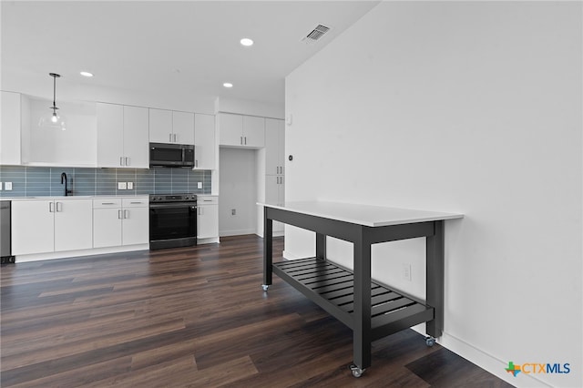 kitchen featuring dark hardwood / wood-style floors, decorative light fixtures, decorative backsplash, white cabinets, and appliances with stainless steel finishes