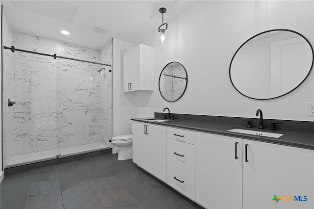 bathroom featuring a tile shower, vanity, and toilet