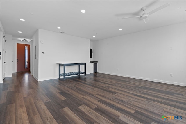 empty room with ceiling fan and dark hardwood / wood-style flooring