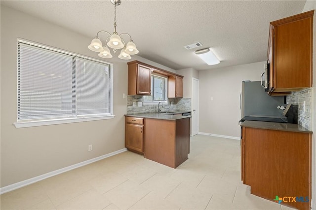 3317 Westrim Dr, Killeen, TX 76549 - kitchen featuring a sink, backsplash, a chandelier, a peninsula, and brown cabinets