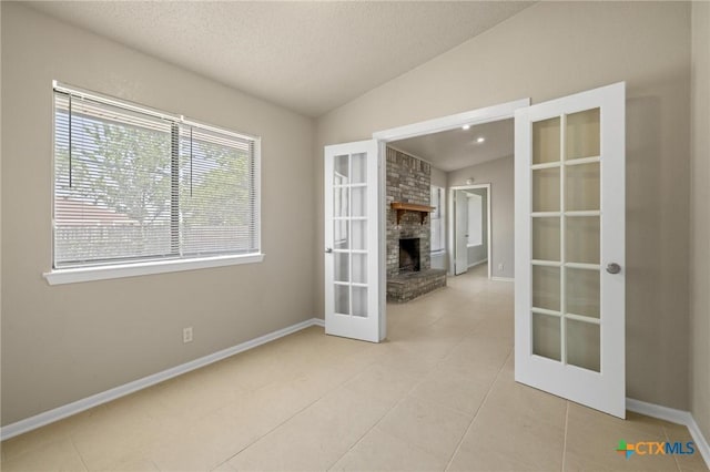 3317 Westrim Dr, Killeen, TX 76549 - unfurnished room featuring french doors, vaulted ceiling, light tile patterned flooring, baseboards, and a textured ceiling