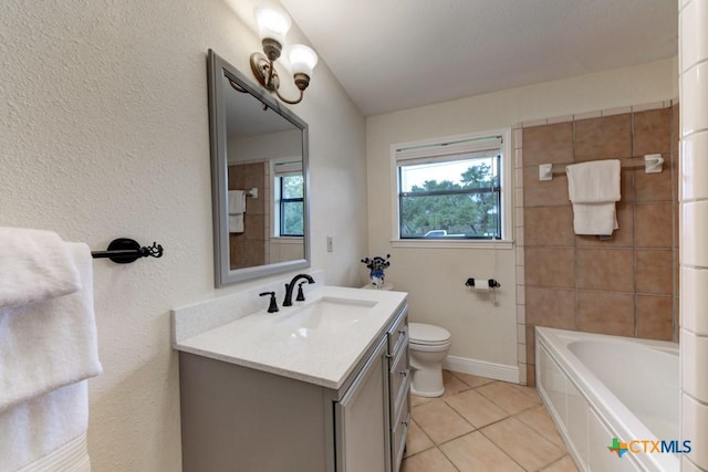 bathroom featuring tile patterned flooring, a tub, baseboards, toilet, and vanity