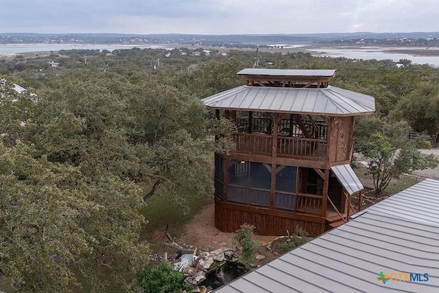 wooden terrace with a wooded view and a water view