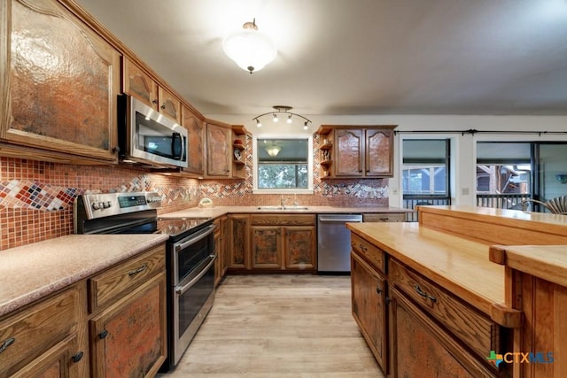 kitchen featuring light wood finished floors, open shelves, butcher block countertops, appliances with stainless steel finishes, and tasteful backsplash