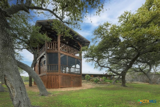 back of property with a yard and a sunroom