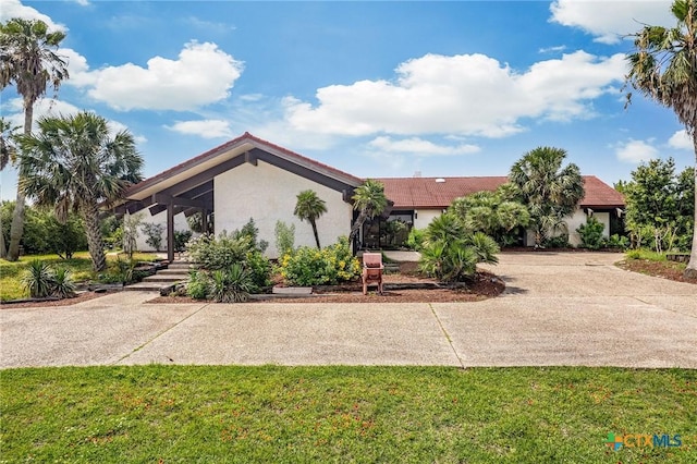 1809 W Harrison Ave, Port Oconnor, TX 77982 - view of front of home featuring stucco siding, a front lawn, and concrete driveway