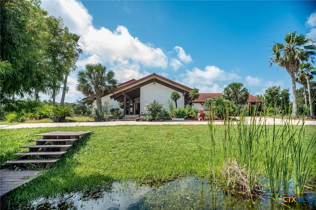 1809 W Harrison Ave, Port Oconnor, TX 77982 - view of front of house featuring a front yard and stucco siding