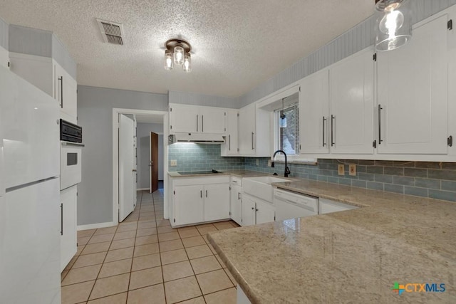 kitchen featuring light tile patterned flooring, sink, white cabinetry, white appliances, and decorative backsplash