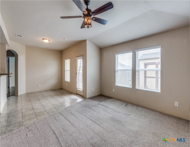1413 Doncaster Dr, Seguin, TX 78155 - tiled spare room featuring lofted ceiling, carpet flooring, arched walkways, visible vents, and ceiling fan