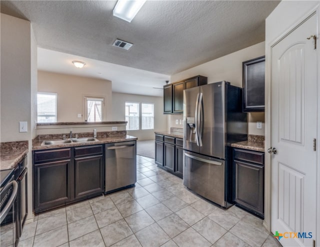 1413 Doncaster Dr, Seguin, TX 78155 - kitchen featuring a sink, a textured ceiling, a peninsula, stainless steel appliances, and visible vents