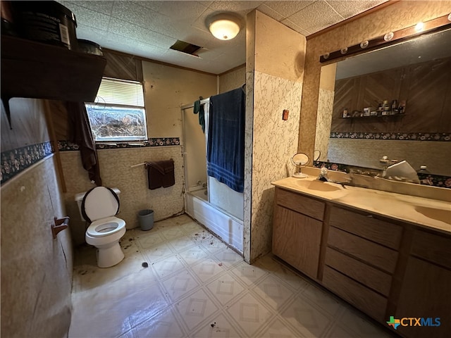 bathroom featuring double vanity, toilet, a sink, tile patterned floors, and bath / shower combo with glass door