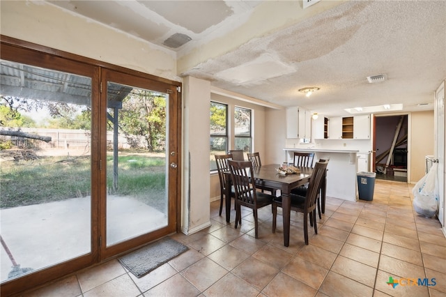 tiled dining space featuring a textured ceiling