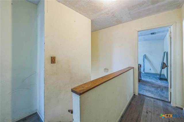 hall with a textured ceiling and hardwood / wood-style flooring