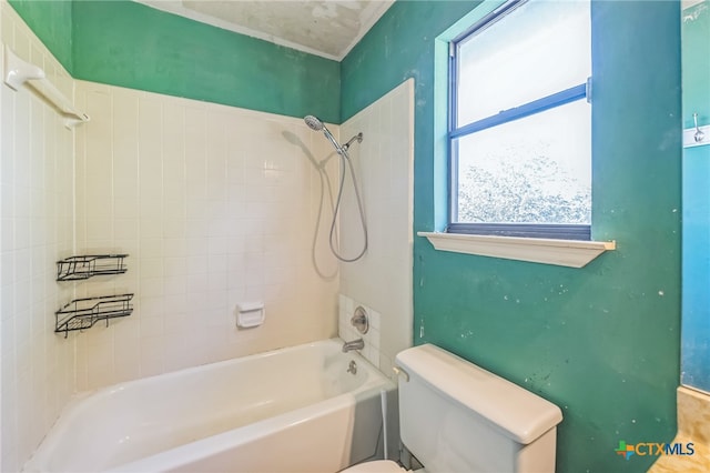 bathroom featuring toilet and tiled shower / bath