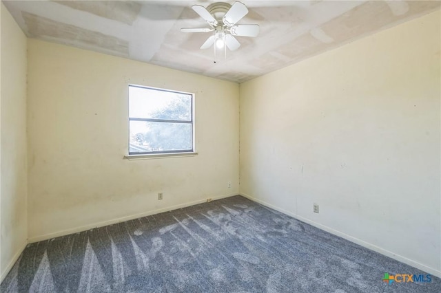 spare room featuring ceiling fan and dark carpet