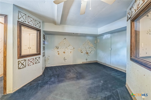 carpeted spare room featuring ceiling fan and a textured ceiling