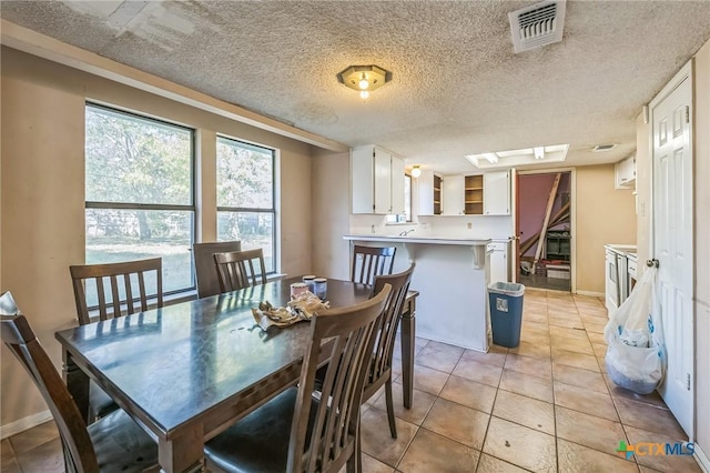 dining room with light tile patterned floors and a textured ceiling