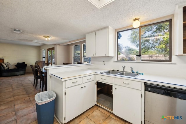 kitchen featuring kitchen peninsula, a textured ceiling, white cabinetry, and stainless steel dishwasher