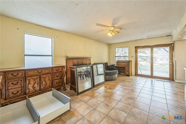 living area with ceiling fan and light tile patterned flooring