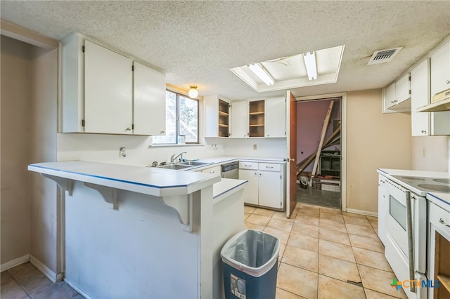 kitchen with white cabinets, a kitchen breakfast bar, kitchen peninsula, and electric stove