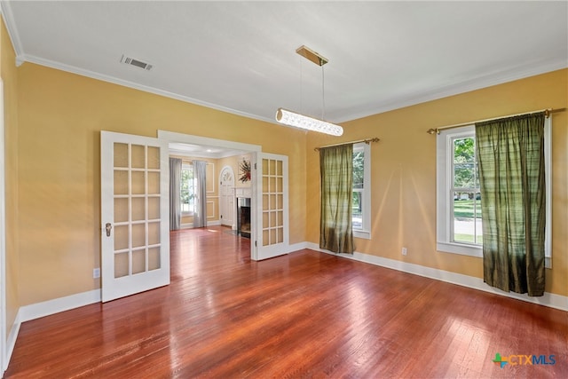 unfurnished room featuring french doors, wood-type flooring, and crown molding